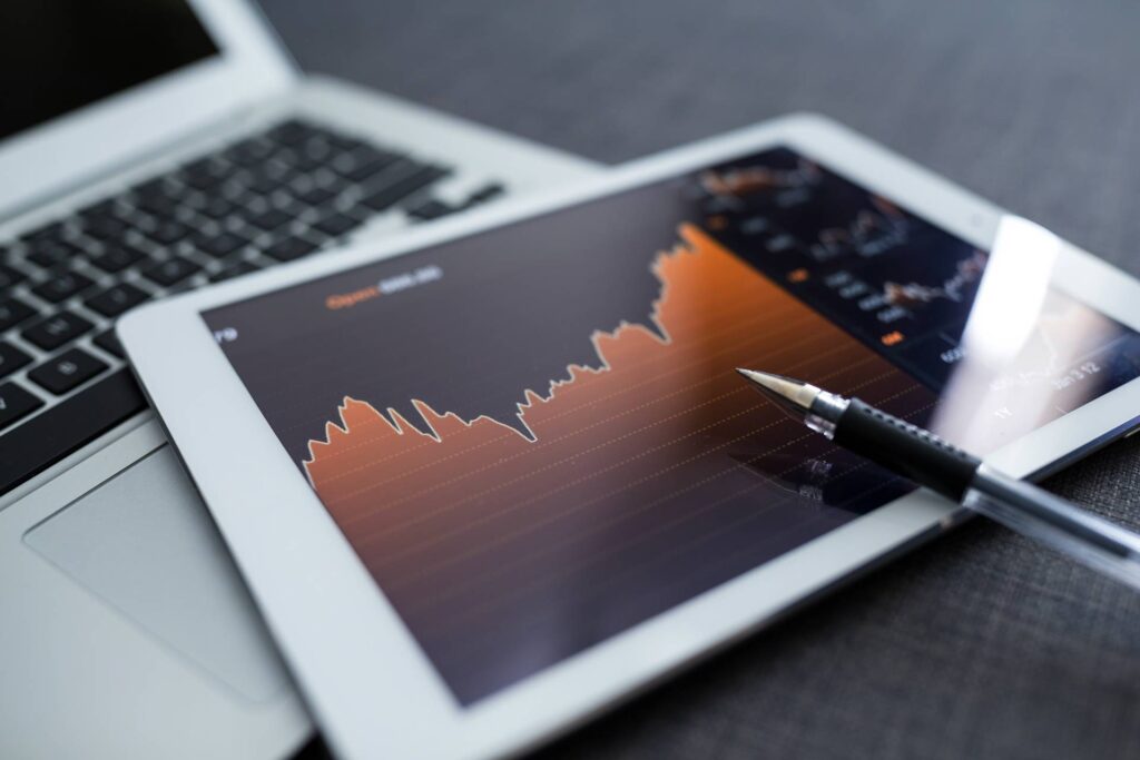 A tablet and a laptop with a market graph.